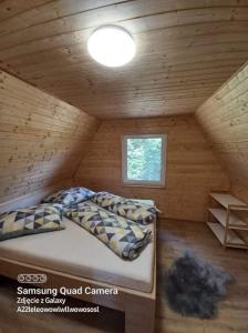 a bedroom with a bed in a wooden cabin at Chata Dominika in Smižany