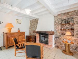 a living room with a stone fireplace and a table at Holiday Home Le havre de paix by Interhome in Créances
