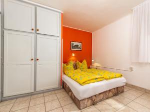 - une chambre dotée d'un lit avec un mur orange dans l'établissement Holiday Home Lisa by Interhome, à Balatonboglár