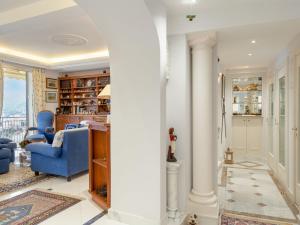 uma sala de estar com colunas brancas e cadeiras azuis em Apartment Grimaldi by Interhome em Mortola Superiore