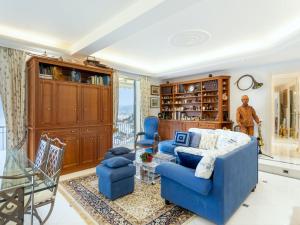 uma sala de estar com um sofá azul e cadeiras em Apartment Grimaldi by Interhome em Mortola Superiore