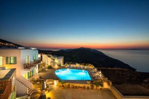 a view of a hotel with a pool at night at Aria Boutique Hotel in Chora Folegandros