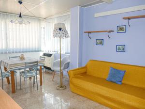 uma sala de estar com um sofá amarelo e uma mesa em Holiday Home Casa della Mamma by Interhome em Riva Ligure