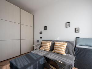 sypialnia z łóżkiem z niebieską pościelą i poduszkami w obiekcie Apartment Borgo San Giulio by Interhome w mieście Pettenasco