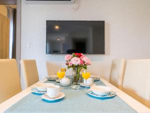 a dining room table with a vase of flowers on it at Holiday Home Sea side mobile home by Interhome in Šilo