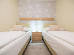 two beds in a room with white sheets at Holiday Home Sea side mobile home by Interhome in Šilo +19 photos
