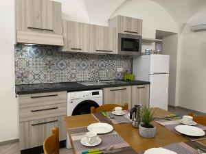 una cucina con un tavolo e un frigorifero bianco di Apartment Tra Sole e Mare by Interhome a Spotorno