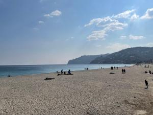 a group of people on a beach near the water at Apartment Tra Sole e Mare by Interhome in Spotorno