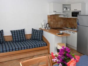 a living room with a couch and a kitchen at Holiday Home T3 Cabine by Interhome in Borgo