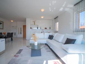 a living room with a white couch and a table at Apartment Martina by Interhome in Vrbnik