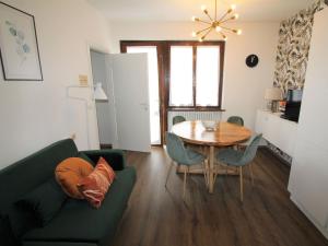 een woonkamer met een groene bank en een tafel bij Apartment Belvedere by Interhome in Ledro