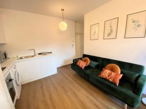 een woonkamer met een groene bank met oranje kussens bij Apartment Belvedere by Interhome in Ledro