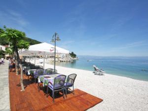 a group of tables and chairs on a beach at Apartment Pinka by Interhome in Mošćenička Draga