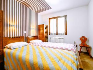 1 dormitorio con 2 camas y ventana en Apartment Cesa Veja by Interhome en Penia