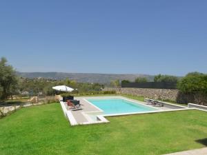 een achtertuin met een zwembad en groen gras bij Villa Paolina by Interhome in Solarino