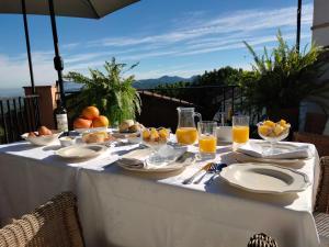einen weißen Tisch mit Speisen und Gläsern Orangensaft in der Unterkunft Les Penyetes Boutique Bed and Breakfast in Campell