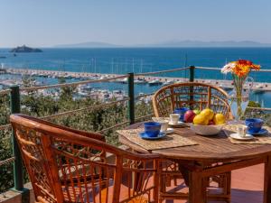 a wooden table with a bowl of fruit on a balcony at Villa Villa Giuliana by Interhome in Punta Ala