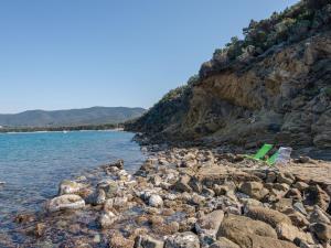 a rocky beach with two chairs and the water at Villa Villa Giuliana by Interhome in Punta Ala