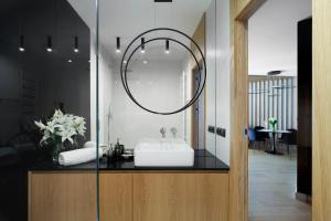 ein Bad mit einem Waschbecken und einem Spiegel in der Unterkunft Elite Apartments Tarasy Bałtyku in Danzig