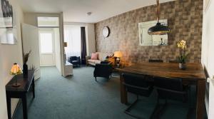 a living room with a table and chairs and a living room at Shoreline Apartment Katwijk in Katwijk aan Zee