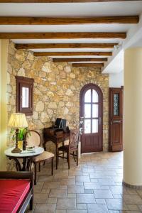 a living room with a table and a stone wall at Aria Boutique Hotel in Chora Folegandros