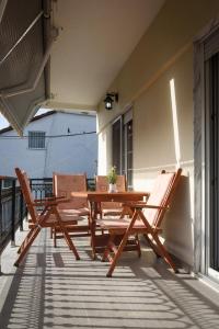 uma mesa de madeira e 2 cadeiras num pátio em Studios Drakontis em Limenas
