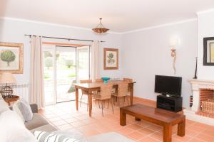 een woonkamer met een tafel en een tv bij Casa Louisa in Casal da Lagoa Seca