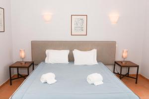een slaapkamer met een bed met twee handdoeken erop bij Casa Louisa in Casal da Lagoa Seca +17 foto's