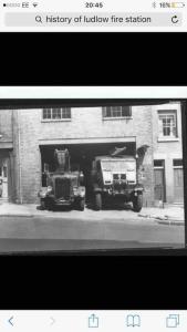 una foto en blanco y negro de dos camiones en un garaje en The Old Fire Station Ludlow, en Ludlow