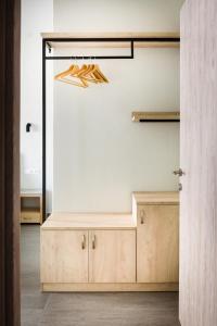 Pokój z białą ścianą i drewnianą szafką w obiekcie Studios Drakontis w mieście Limenas