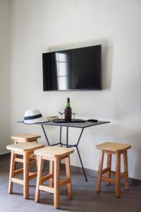 a table with four chairs and a tv on a wall at Studios Drakontis in Limenas