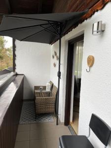 a patio with a table and an umbrella at BacherlHouse - Apt Miglbach in Schörfling