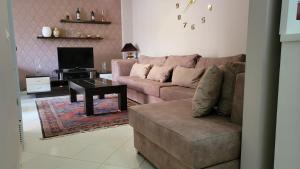 a living room with a couch and a table at Charming Apartment Lushnje in Lushnjë
