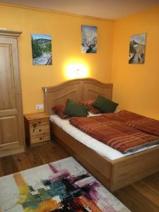 1 dormitorio con 1 cama con cabecero de madera en Haus Greet, en Muhr