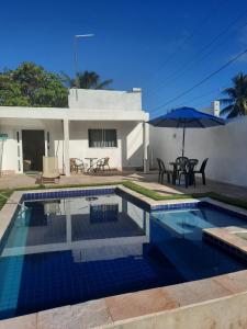 a swimming pool in front of a house at Casa Vitória em barra de jacuipe in Campos