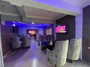 una sala da pranzo con sedie, tavolo e TV di Alluring View Hotel - Allen Avenue a Lagos