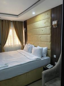 ラゴスにあるAlluring View Hotel - Allen Avenueのベッドルーム1室(ベッド1台、窓、椅子付)