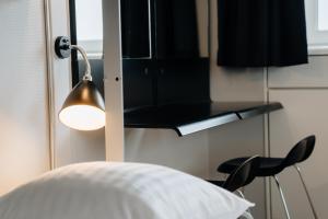a bedroom with a bed and a lamp and a chair at Danhostel Copenhagen City in Copenhagen