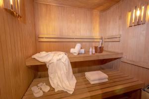 a sauna with a wooden shelf and towels in it at Runa Moraira Apart & Spa in Mar de las Pampas