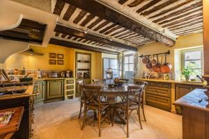 a kitchen with a wooden table and chairs at Pavillon Lou in Crillon-le-Brave