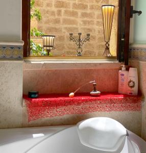 a bathroom with a sink and a mirror and a tub at Palazzo Morola XIV century in Giovinazzo