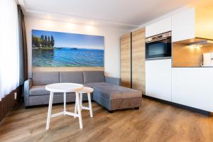 博登斯边的伊门施塔特Ferienwohnpark Immenstaad am Bodensee Ein-Zimmer-Apartment 53 20的客厅里有一张沙发和一张桌子。