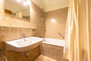La salle de bains est pourvue d'un lavabo et d'une baignoire. dans l'établissement Ferienwohnpark Immenstaad am Bodensee Ein-Zimmer-Apartment 49 41, à Immenstaad am Bodensee