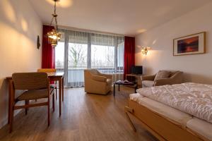 una camera con letto, tavolo e sedie di Ferienwohnpark Immenstaad am Bodensee Ein-Zimmer-Apartment 49 31 a Immenstaad am Bodensee