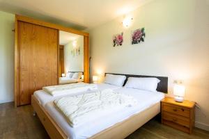 1 dormitorio con 1 cama grande y puerta de madera en Ferienwohnpark Immenstaad am Bodensee Zwei-Zimmer-Apartment 49 47, en Immenstaad am Bodensee