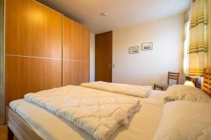 1 dormitorio con 2 camas y armarios de madera en Ferienwohnpark Immenstaad am Bodensee Zwei-Zimmer-Apartment 53 01, en Immenstaad am Bodensee
