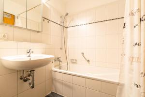 uma casa de banho branca com um lavatório e uma banheira em Ferienwohnpark Immenstaad am Bodensee Zwei-Zimmer-Apartment 49 19 em Immenstaad am Bodensee