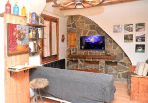 uma sala de estar com uma lareira de pedra e uma televisão em Piso rústico-moderno 6 plazas - Pobla de Lillet em La Pobla de Lillet