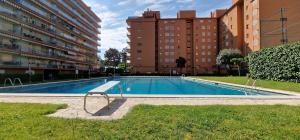 uma piscina com um banco ao lado de alguns edifícios em Vivalidays Luis em Santa Susanna