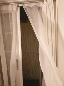 a window with white curtains in front of a door at Cozy Muswell Hill 1-Bedroom Flat in London